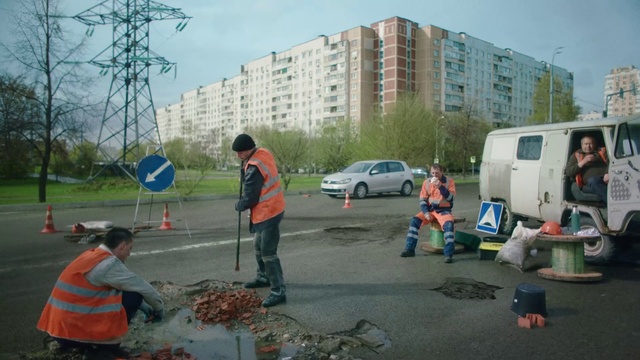 Video Reference: Building, Sky, Plant, Cloud, Vehicle, Tire, Road surface, Asphalt, Tree, Motor vehicle