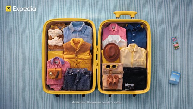 Video Reference: suitcase, travel, packing, clothes, accessories, wardrobe, yellow, blue background, overhead view, organized, vacation, luggage, fashion, hat, sunglasses, camera