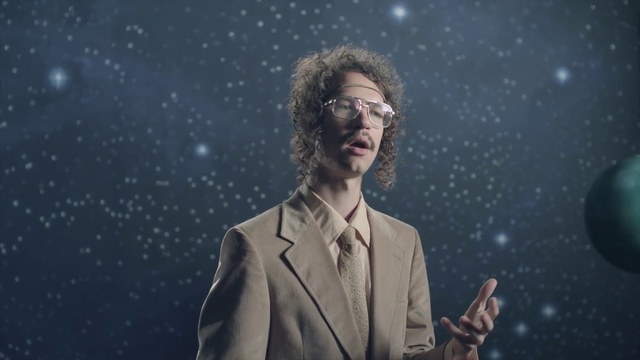 Video Reference: Glasses, Vision care, Flash photography, Sky, Music artist, Gesture, Beard, Entertainment, Suit, Blazer