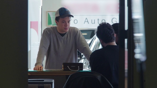 Video Reference: Standing, Audio equipment, Cap, Baseball cap, Gadget, T-shirt, Event, Electronic device, Conversation, Hat