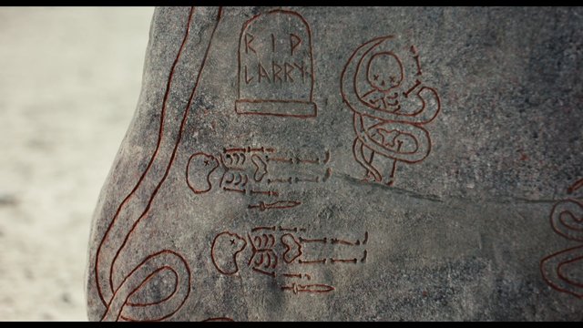 Video Reference: stone, engraving, red markings, skull, skeleton, tombstone, RIP, close-up, graffiti, symbol, carving, weathered surface, artwork, mystery, dark