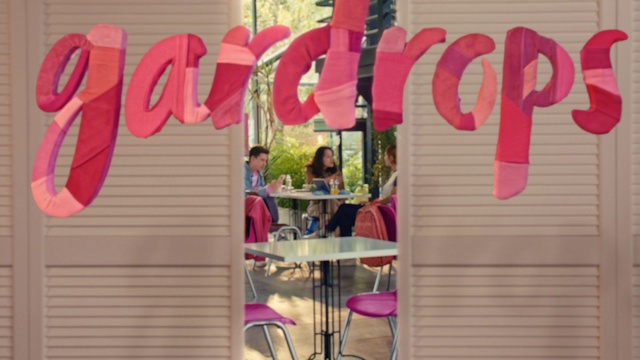 Video Reference: Pink, Magenta, Font, Material property, Beauty, Event, Chair, T-shirt, Facade, Peach