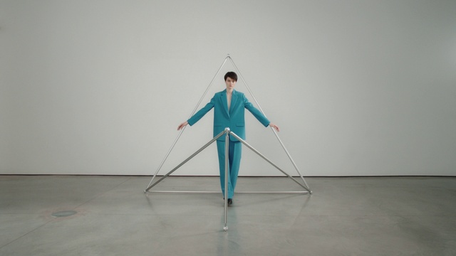 Video Reference: Outerwear, Art, Musical instrument, Electric blue, Balance, Visual arts, Event, Fun, Recreation, Sitting