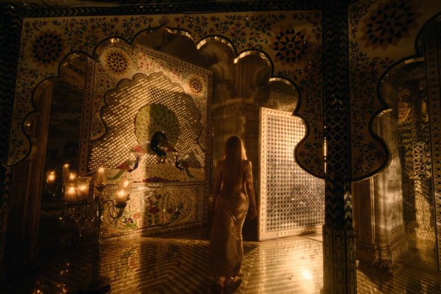 Video Reference: ornate interior, mosaic, arches, candles, mirror, woman, dress, doorway, warm light, interior design, decorative wall, luxury, traditional style, indoor scene, low light