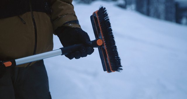 Video Reference: snow, winter, snow brush, broom, gloves, jacket, cleaning, outdoor, close-up, cold, ice, snow removal, hand tool, snowy background