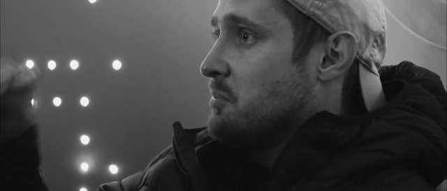 Video Reference: Nose, Chin, Outerwear, Eyebrow, Mouth, Black, Flash photography, Jaw, Black-and-white, Beard