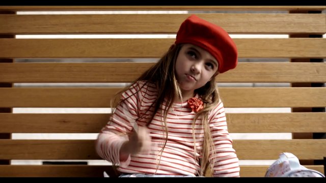 Video Reference: girl, child, beret, striped shirt, bench, wooden background, portrait, indoor, casual, fashion, sitting, close-up