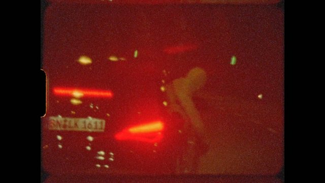 Video Reference: night, traffic, car, tail lights, windshield, blurred, low light, city lights, road, vehicle, red lights, motion blur