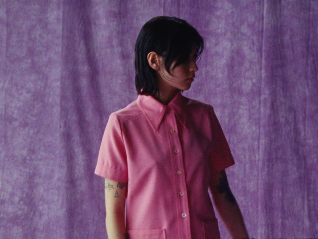 Video Reference: Dress shirt, Purple, Sleeve, Flash photography, Gesture, Collar, Pink, Magenta, Fashion design, Entertainment