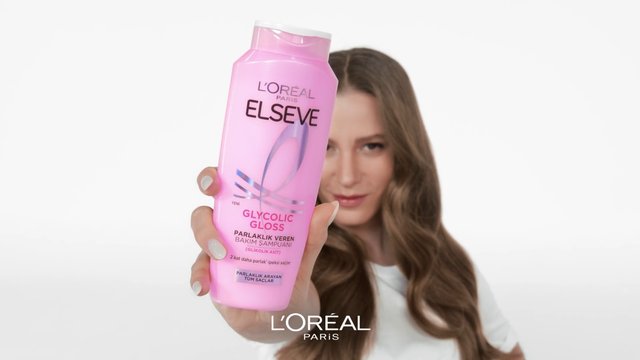 Video Reference: woman, haircare, shampoo, bottle, pink, product shot, cosmetic, advertisement, white background, long hair, beauty, handheld, brand, L'Oreal, Elseve, gloss