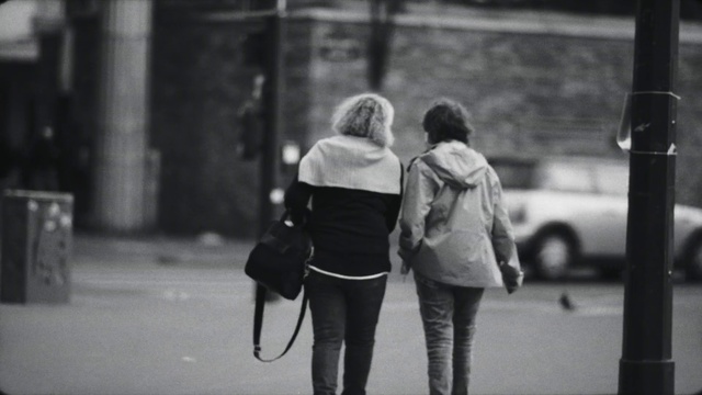 Video Reference: Standing, Black-and-white, Gesture, Grey, Style, Road surface, Luggage and bags, Sidewalk, Monochrome, Road