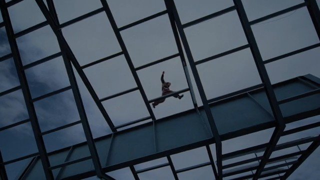 Video Reference: person, silhouette, falling, suspended, roof, glass ceiling, metal structure, architecture, sky, low angle, action, urban, indoor, dramatic, ceiling