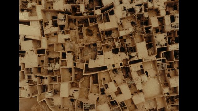 Video Reference: aerial, overhead, desert, ruins, earthen structures, architecture, fortified settlement, tan, abstract pattern, historic, rural, maze-like, mudbrick, landscape