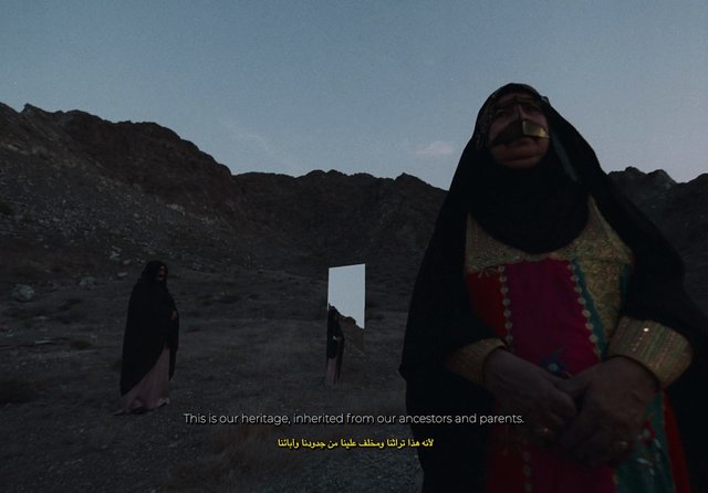 Video Reference: desert, rocky landscape, woman, traditional clothing, head covering, mirror, outdoor, subtitles, heritage, dusk, portrait, solitary, heritage costume, arid, mountains