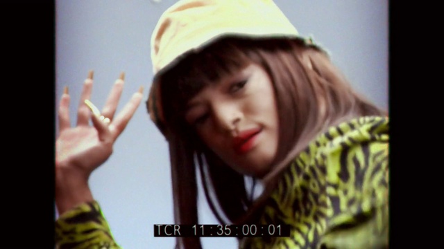 Video Reference: Lip, Outerwear, Eyebrow, Cap, Eyelash, Flash photography, Neck, Gesture, Yellow, Happy