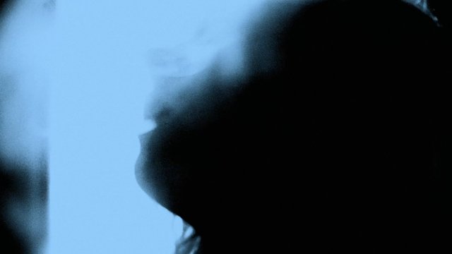 Video Reference: silhouette, profile, close-up, out of focus, blurred, person, face, blue background, low light, abstract, soft focus, indoor