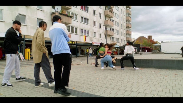 Video Reference: Footwear, Trousers, Shoe, Building, Window, Travel, Hat, Urban design, Sky, Leisure