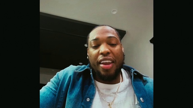 Video Reference: Forehead, Chin, Flash photography, Jaw, Beard, Gesture, T-shirt, Audio equipment, Eyewear, Electric blue