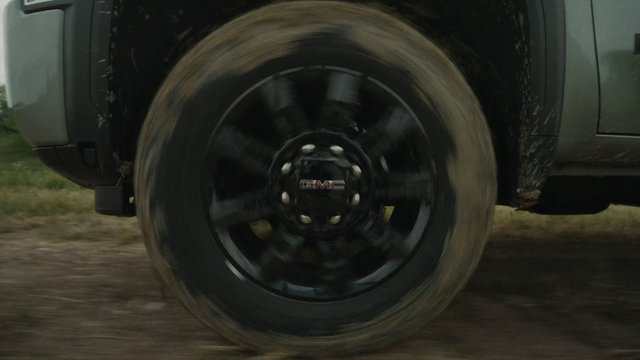 Video Reference: truck, wheel, tire, spinning, motion blur, vehicle, off-road, mud, close-up, transportation, driving, road, all-terrain, GMC