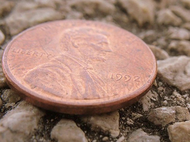 Video Reference: penny, coin, copper, currency, close-up, macro, gravel, stone, money, tilted, texture, ground, outdoors, fiscal, small object
