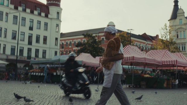 Video Reference: Sky, Building, Travel, City, Hat, Road, Pedestrian, Event, Fun, Leisure