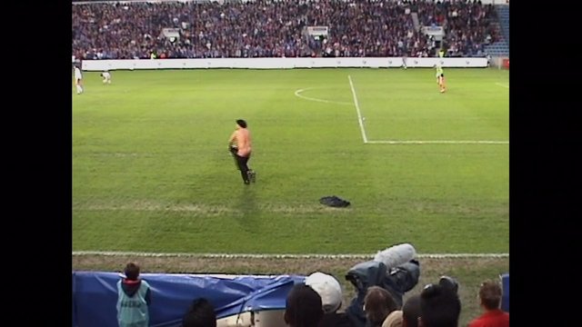 Video Reference: soccer, football, stadium, sports, crowd, field, match, goalkeeper, broadcast, television, outdoor, grass, spectators, action, wide shot