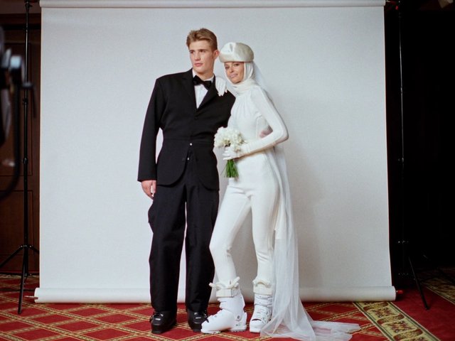 Video Reference: studio, portrait, couple, formalwear, tuxedo, white outfit, veil, bouquet, photoshoot, fashion, backdrop, posing, bridal, full body, indoor, wedding style