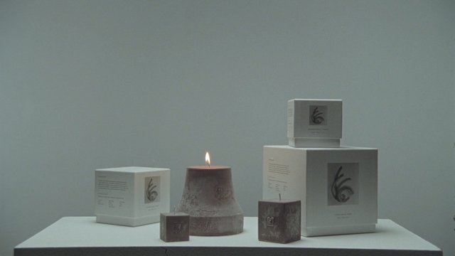 Video Reference: product display, candles, packaging, minimalist, still life, table, lit candle, boxes, neutral background, studio shot, merchandise, arrangement