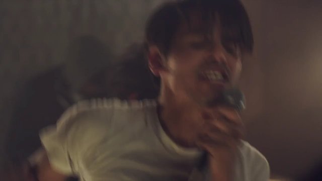 Video Reference: person, microphone, singing, shouting, indoor, close-up, blurry, performance, music, motion blur, low light, portrait