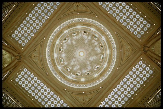 Video Reference: ornate ceiling, domed interior, architectural detail, symmetry, geometric pattern, decorative dome, interior design, lattice panels, floral pattern, circular dome, luxury architecture, ceiling lights, golden tones, classical decor