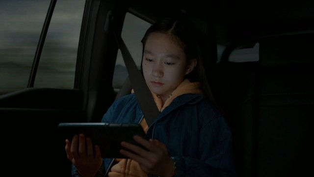 Video Reference: girl, child, car interior, back seat, seatbelt, tablet, travel, portrait, passenger, device, indoors, vehicle