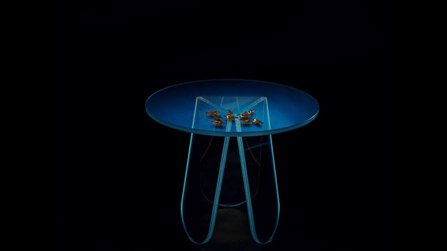 Video Reference: glass table, side table, modern furniture, minimalist, blue, translucent, product shot, isolated, black background, design object, interior decor