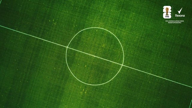 Video Reference: soccer, football, field, pitch, center circle, midfield line, green grass, sports, stadium, aerial view, sponsor logo, FIFA, Rexona, broadcast, turf