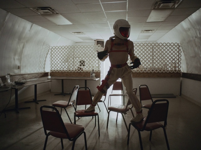 Video Reference: Furniture, Chair, Helmet, Standing, Table, Interior design, Style, Hat, Flooring, Floor