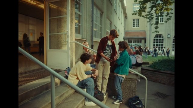 Video Reference: students, outdoor, steps, campus, building, group, teenagers, social, conversation, backpack, courtyard, daylight, urban, school, casual