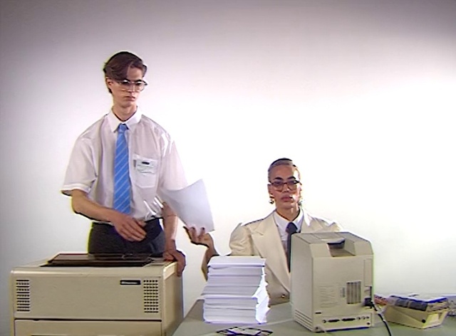 Video Reference: Outerwear, Dress shirt, Cabinetry, Sleeve, Output device, Gesture, Computer monitor, Tie, Office supplies, Office equipment