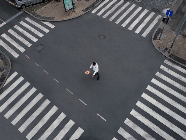 Video Reference: intersection, crosswalk, aerial, overhead, city, street, pedestrian, road, urban, empty, traffic, walking, pizza, drink, corner, architecture