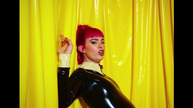 Video Reference: Textile, Latex clothing, Lipstick, Entertainment, Fashion design, Curtain, Latex, Jacket, Performing arts, Magenta