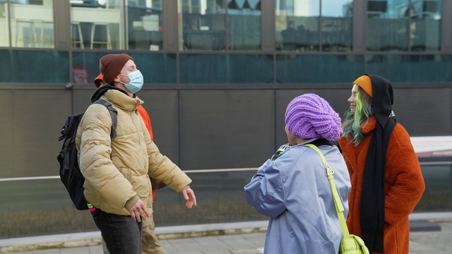 Video Reference: Clothing, Daytime, Eye, Infrastructure, Standing, Gesture, Cap, Headgear, Road surface, Jacket