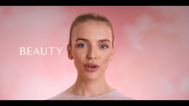 Video Reference: beauty, woman, close-up, portrait, pink background, cosmetics, fashion, studio, face, blue eyes, text, minimal, soft lighting