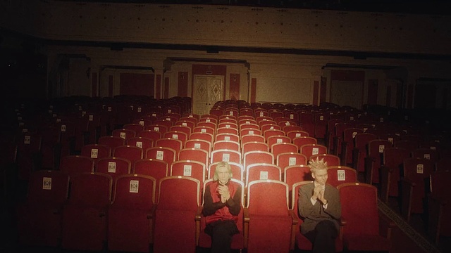 Video Reference: Entertainment, Chair, Performing arts, Event, Font, Music, Crowd, Darkness, Art, Musical instrument accessory