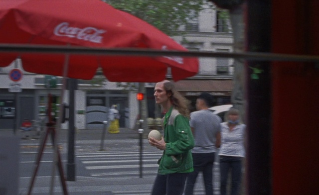 Video Reference: Shorts, City, Road, Luggage and bags, Pedestrian, Traffic light, signaling device, T-shirt, Telephone booth, Street