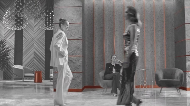 Video Reference: Trousers, Human, Standing, Grey, Performing arts, Style, Entertainment, Chair, Fashion design, Event