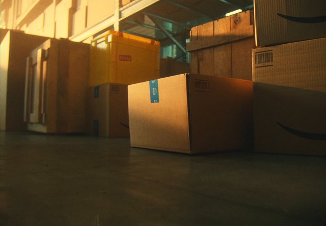 Video Reference: cardboard boxes, shipping, warehouse, storage, packaging, delivery, stacked boxes, indoors, sunlight, industrial, cargo, logistics, floor, box closeup