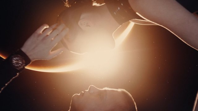 Video Reference: people, close-up, backlit, glare, light flare, dark background, dramatic lighting, face, hand, silhouette, interior, artistic, moody