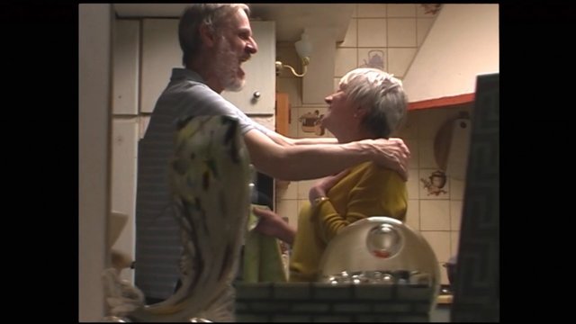 Video Reference: kitchen, older adults, couple, embrace, smiling, interior, home, conversation, standing, warm lighting, candid, domestic, relationship, portrait, indoor, lifestyle