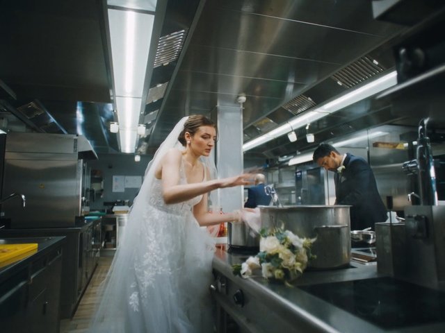 Video Reference: bride, wedding dress, veil, commercial kitchen, chef, man in suit, large pot, bouquet, indoor, stainless steel, countertop, cooking, kitchen, wedding