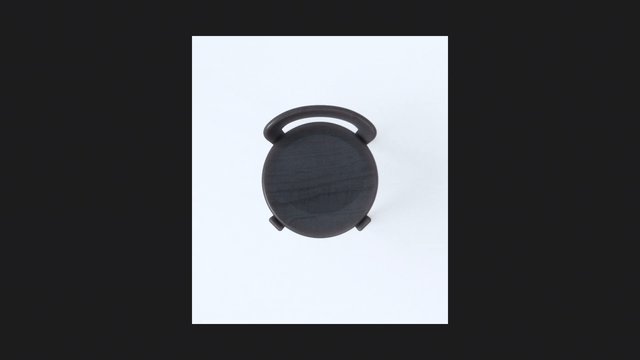 Video Reference: round object, black, top view, handle, minimal, isolated, light background, product shot, abstract, symmetrical, centered, simple