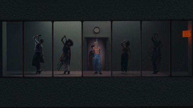 Video Reference: stage, performance, dancers, theater, dim lighting, elevator, exit sign, silhouette, group, dramatic, panel split, indoor, fashion