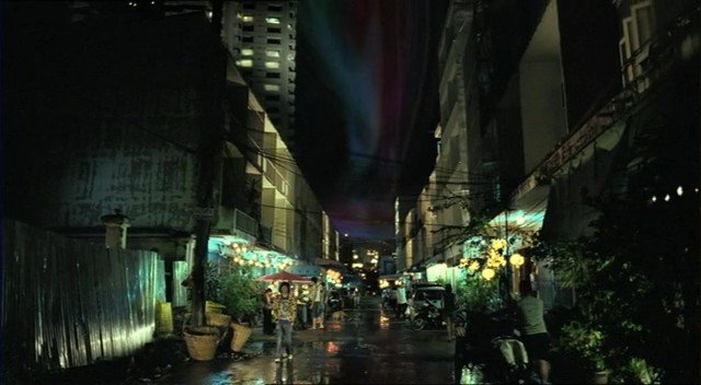 Video Reference: night, street, urban, wet pavement, buildings, shops, stalls, city, dark, lights, alley, traffic, people, rain, reflection, crowded